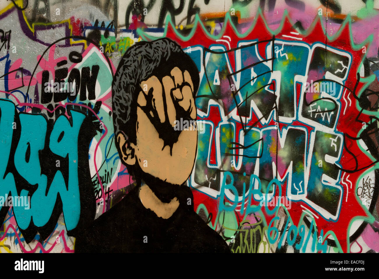 Graffiti street art muro di Berlino volto cartoon lettere Foto Stock