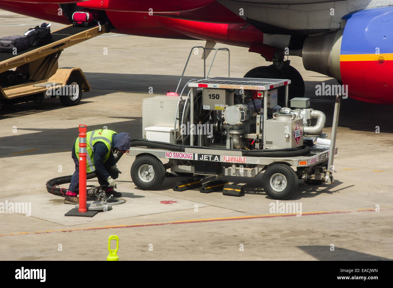 Equipaggio a terra utilizzando un mobile della pompa carburante per riempire i serbatoi di Southwest Airlines piano. Foto Stock