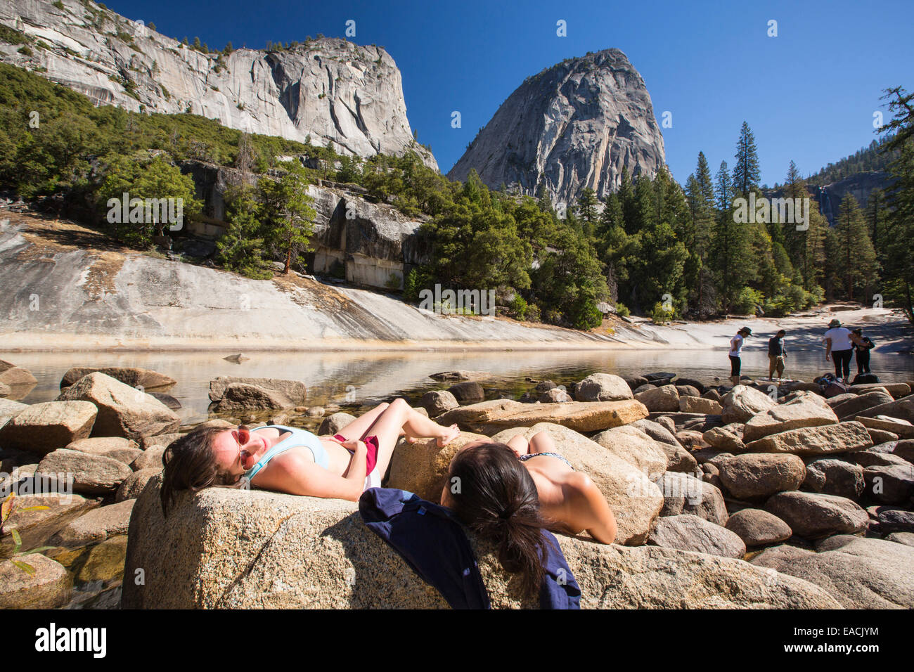 Le giovani donne a prendere il sole in una piscina al di sopra del Nevada Fall nella piccola valle di Yosemite, Yosemite National Park, California, Stati Uniti d'America. Foto Stock