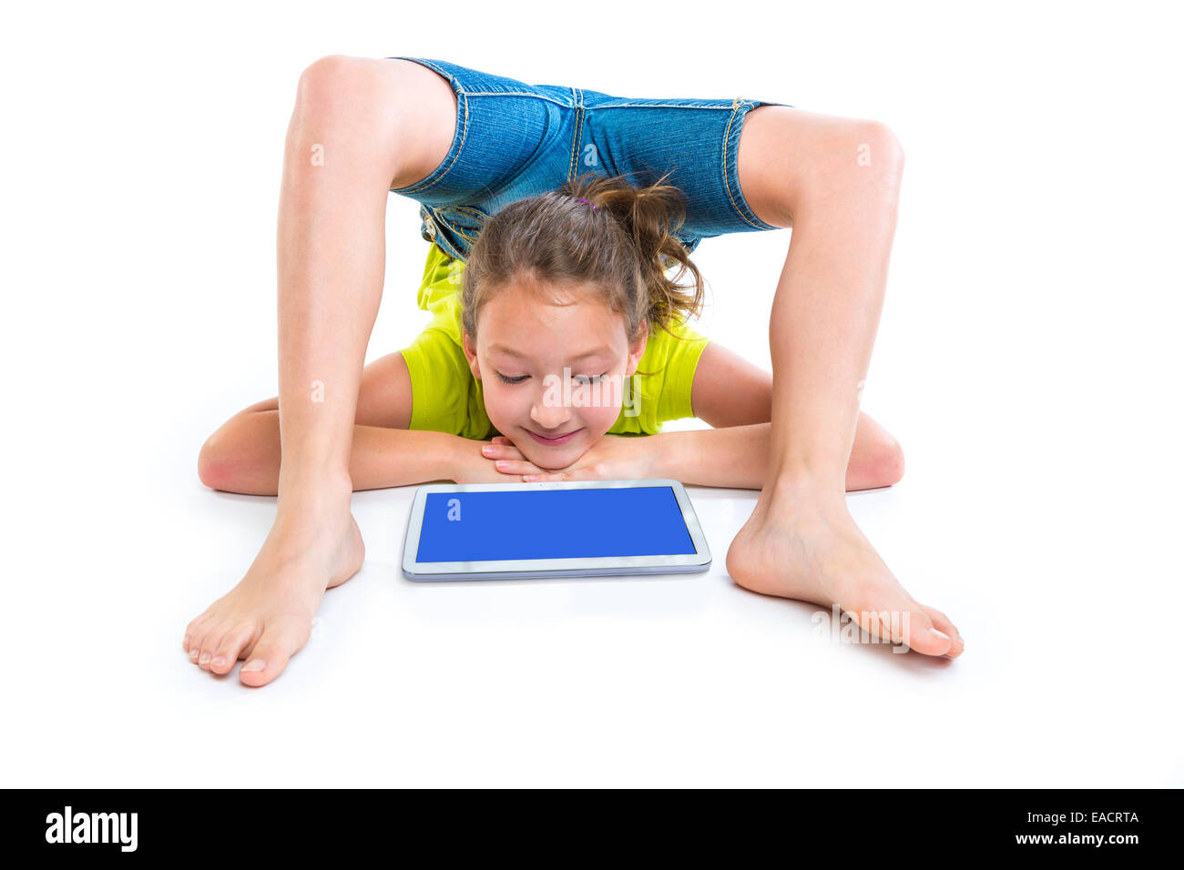Contortionist flessibile kid ragazza che gioca con il tablet pc su sfondo bianco Foto Stock