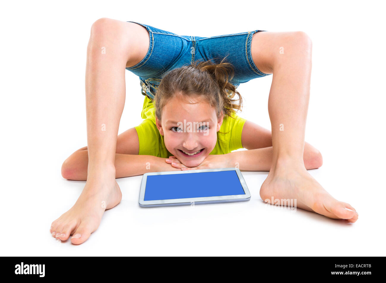 Contortionist flessibile kid ragazza che gioca con il tablet pc su sfondo bianco Foto Stock
