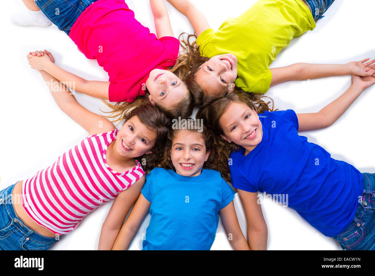 Capretto felice amico gruppo di ragazze sorridenti vista aerea che giace sul cerchio su sfondo bianco tenendo le mani Foto Stock