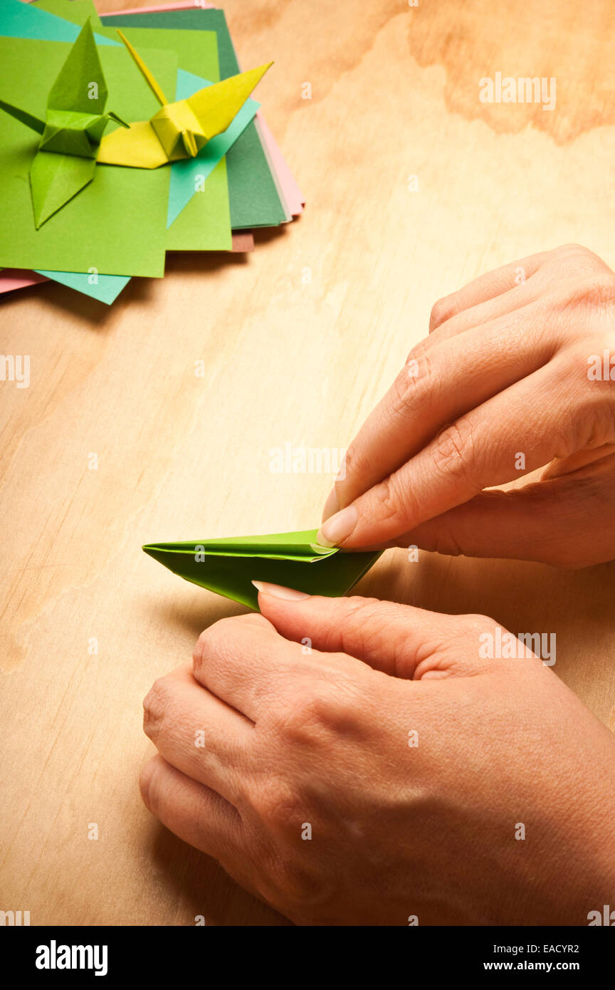 Donna piegando la carta per origami Foto Stock