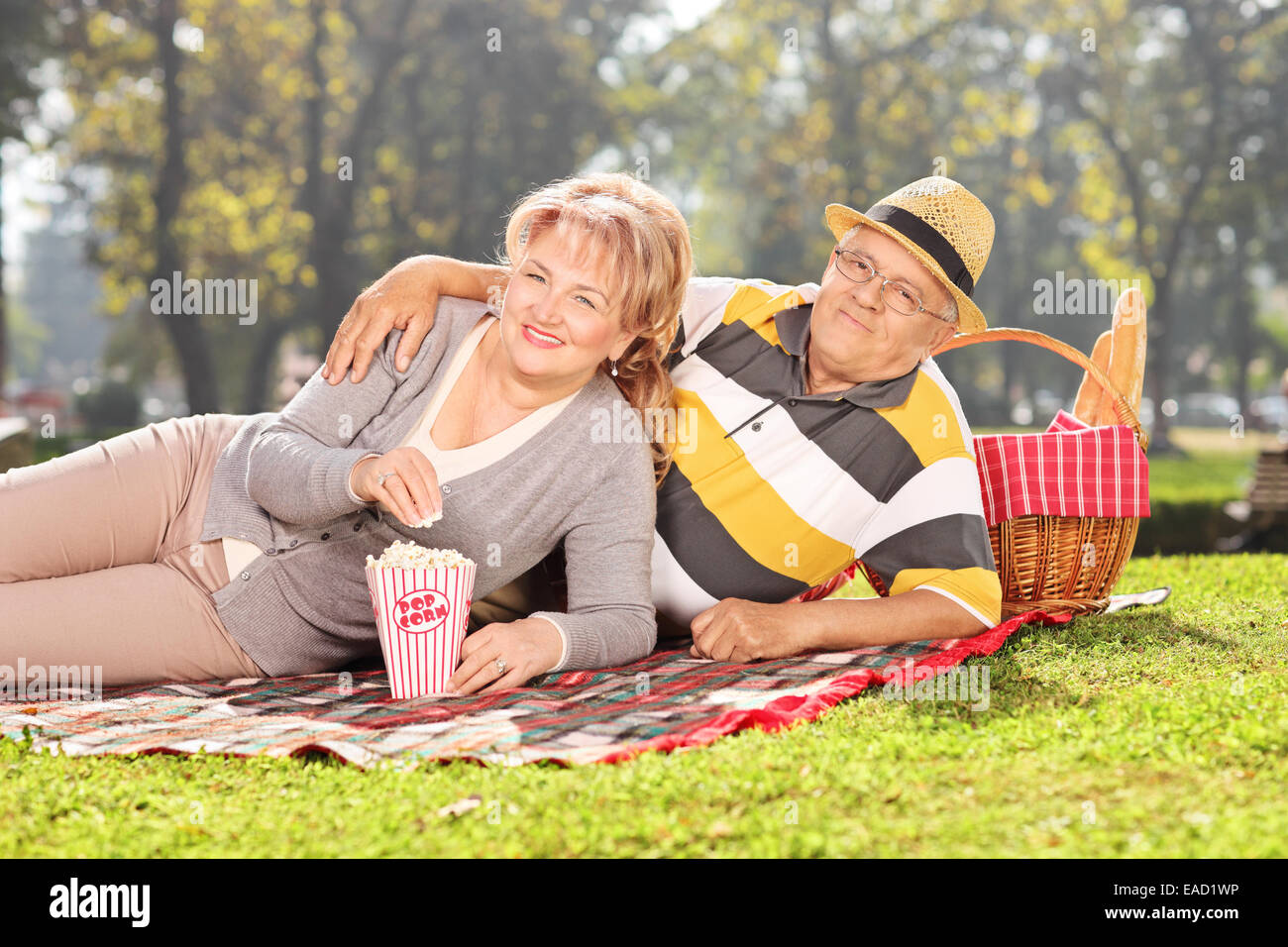 Coppia matura godendo di un picnic nel parco in una giornata di sole Foto Stock