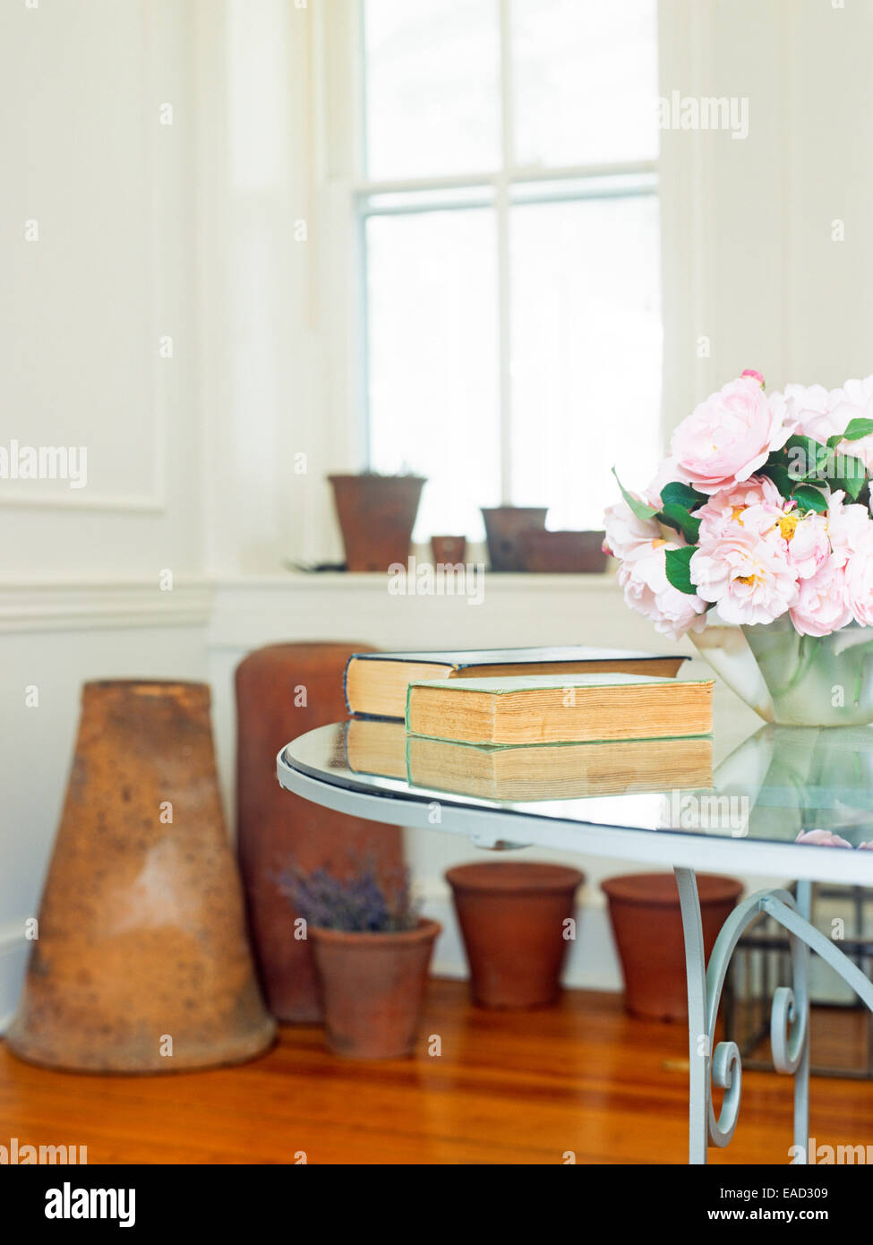 Sala interna con glas tavolo e rose e fiori invasati Foto Stock