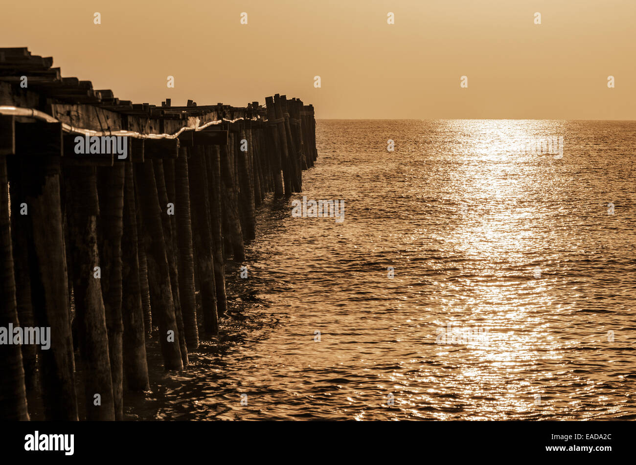 Il vecchio ponte di legno a sunrise di color seppia in zone rurali della Thailandia Foto Stock