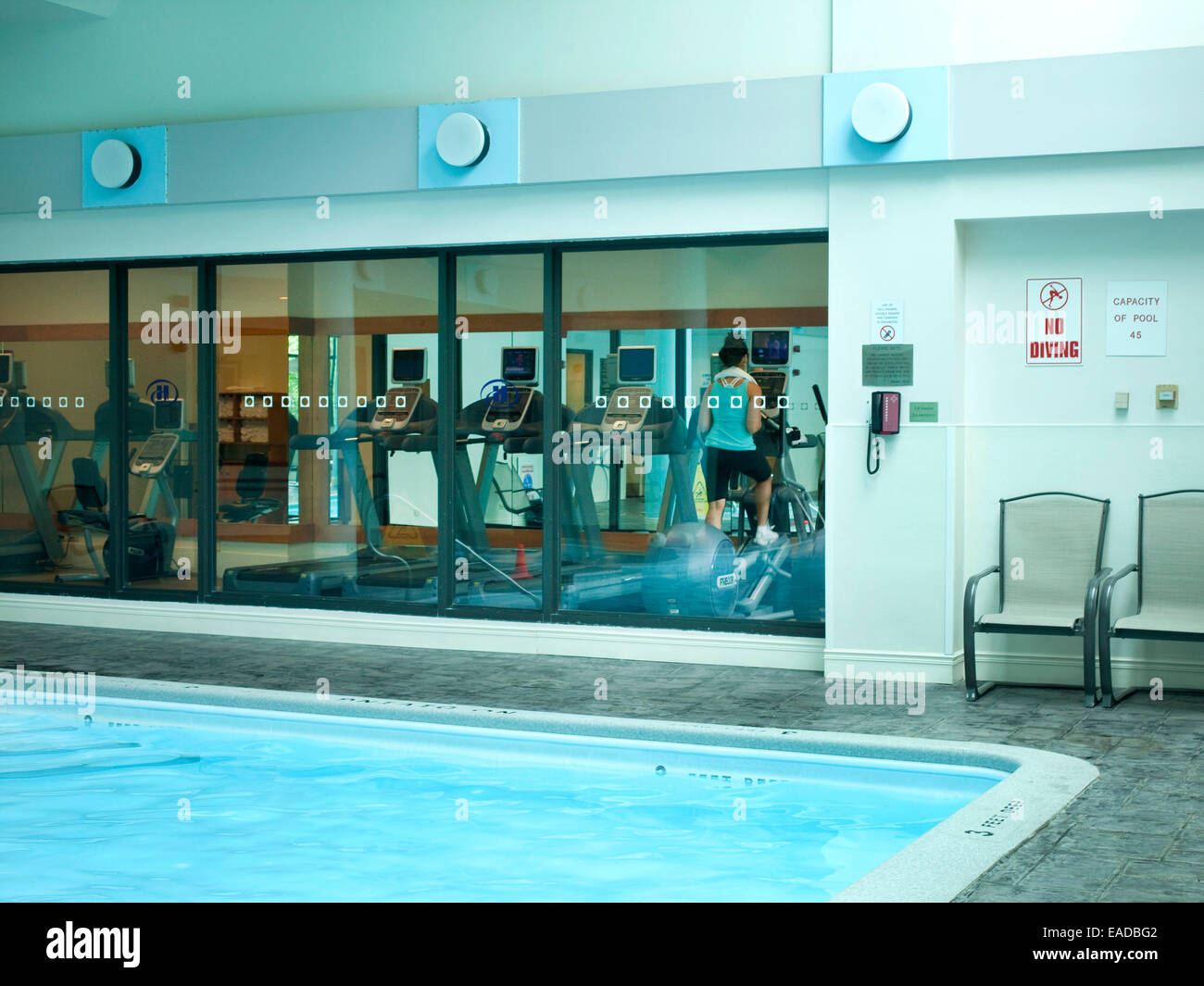 La piscina e la donna che esercitano in hotel Foto Stock