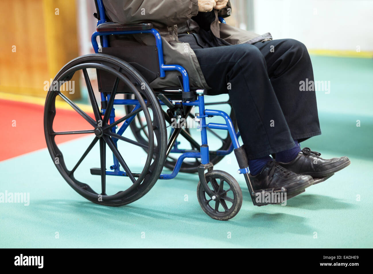 Disabili uomo senior utilizzando una sedia a rotelle in un ospedale Foto Stock