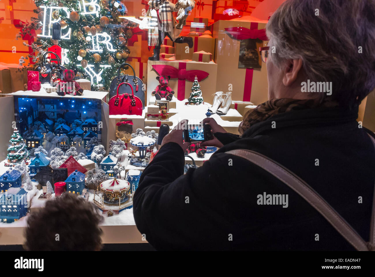 Parigi, Francia, Donna fotografare, Window Shopping, fotografare, Smart Phone, Magazzini francesi, godendo le luci di Natale, decorazioni, visualizzare le Printemps, (credito: Jean-Claude Dehix), Burberry Luxury brand della moda Foto Stock