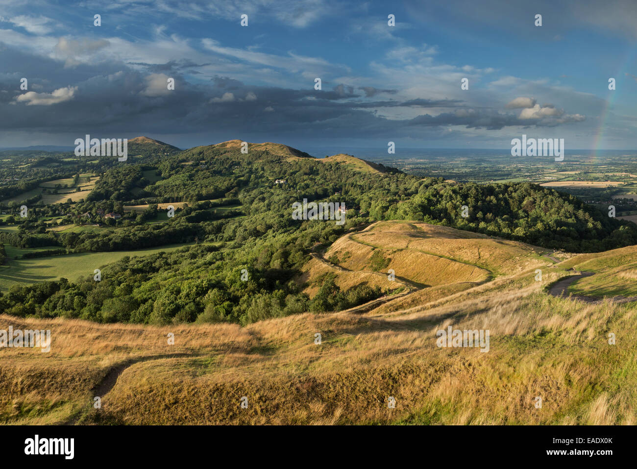 La bastionata di British Camp, Herefordshire sono illuminati dal sole al tramonto mentre la pioggia nuvole si raccolgono al di sopra della Malvern Hills Foto Stock