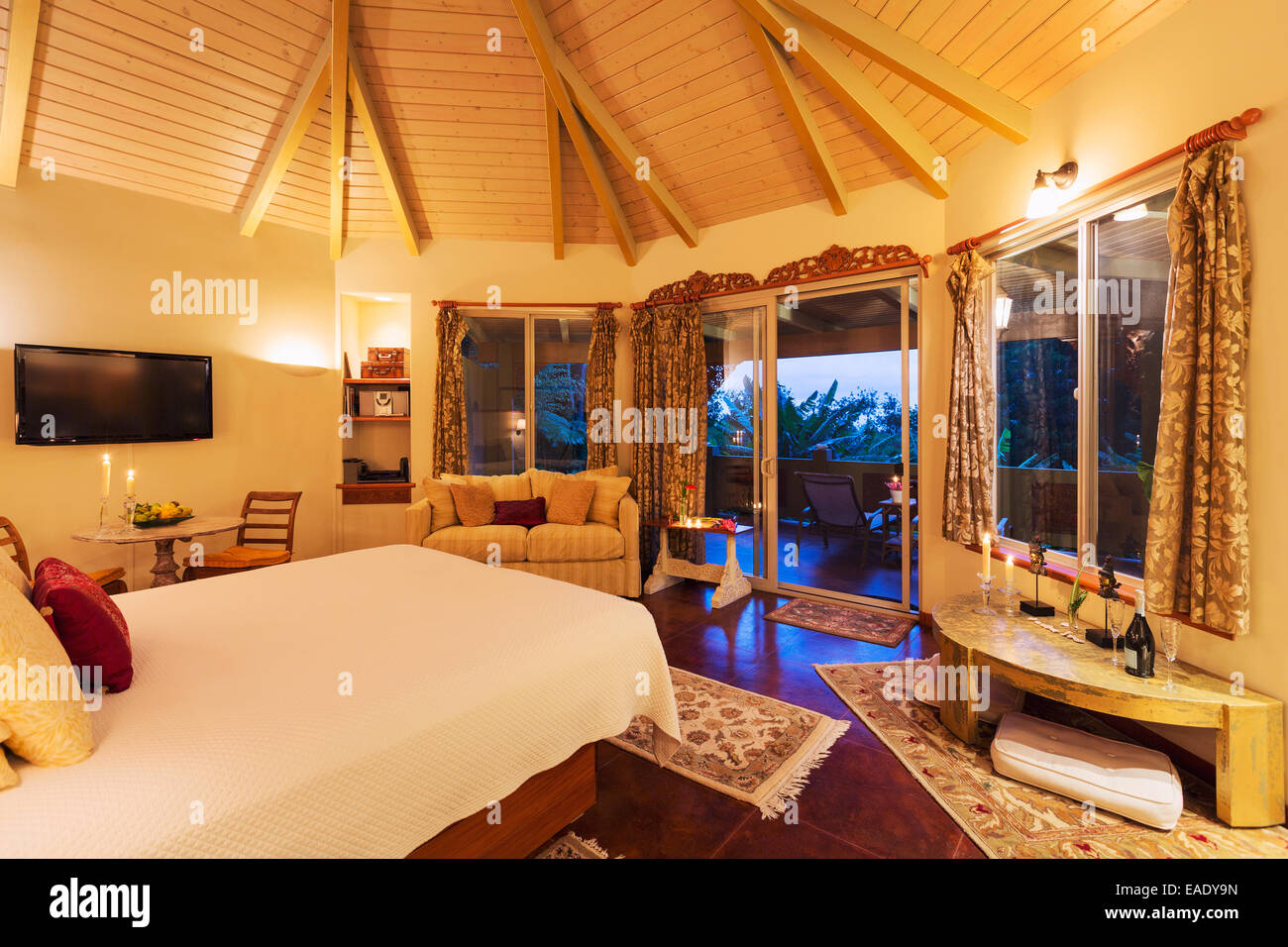 Romantica camera da letto accogliente con pavimenti in legno duro al tramonto. Home Interior Design Foto Stock