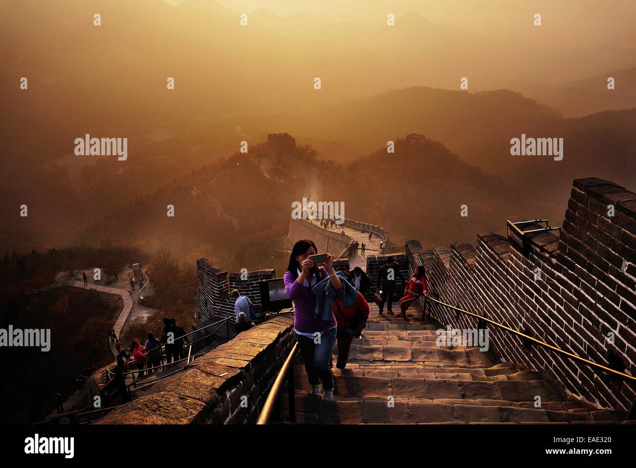 La Grande Muraglia della Cina sorge al tramonto sopra il paesaggio circostante coperto dallo smog presso Badaling, circa 70 chilometri a nord-ovest di Pechino nella contea di Yanqing, Cina. La Grande Muraglia si estende attraverso la storica i confini del nord della Cina e con esso è Foto Stock