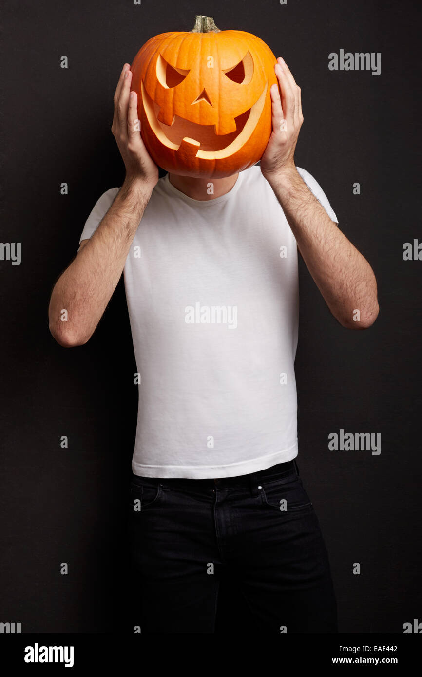Zucca di Halloween sulla testa di uomo, scherzando Foto Stock