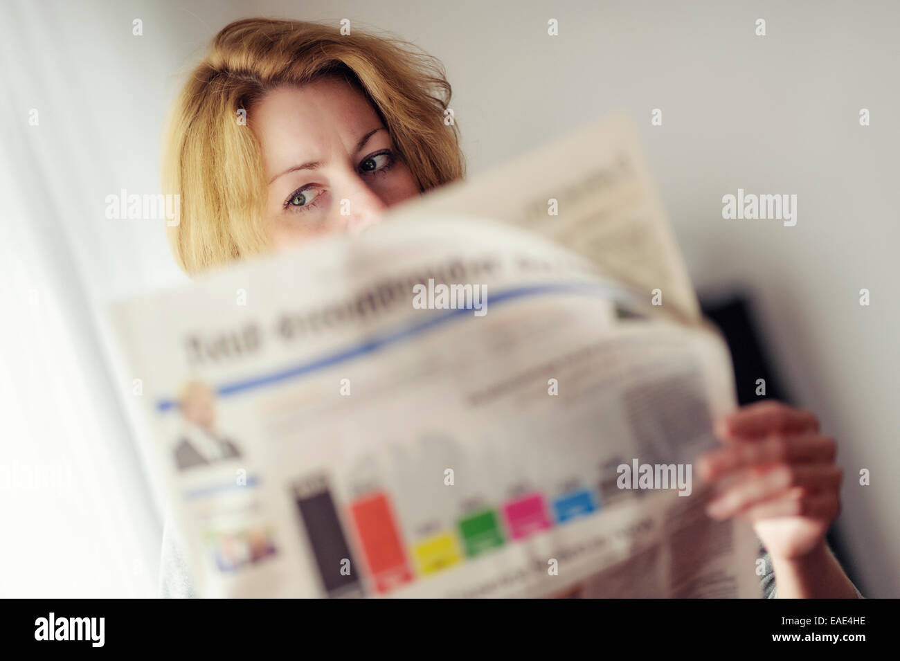 Giovane donna leggendo un giornale con la prognosi della tedesca elezione federale, Germania Foto Stock