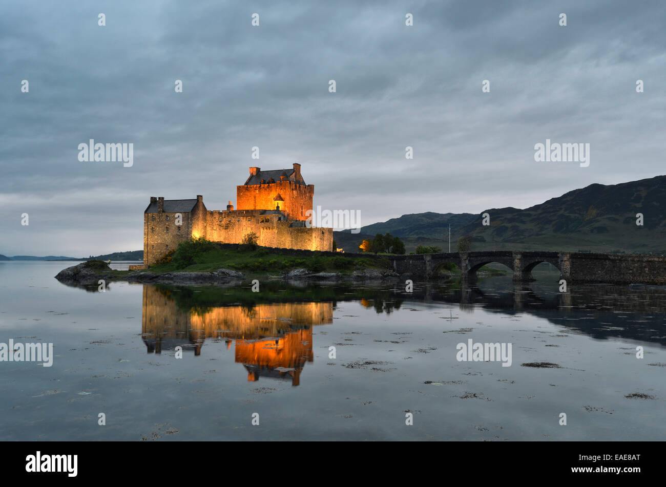 Eilean Donan Castle, sede ancestrale del clan scozzesi di Macrae, riflessa in Loch Duich in serata, Dornie, Highlands Foto Stock