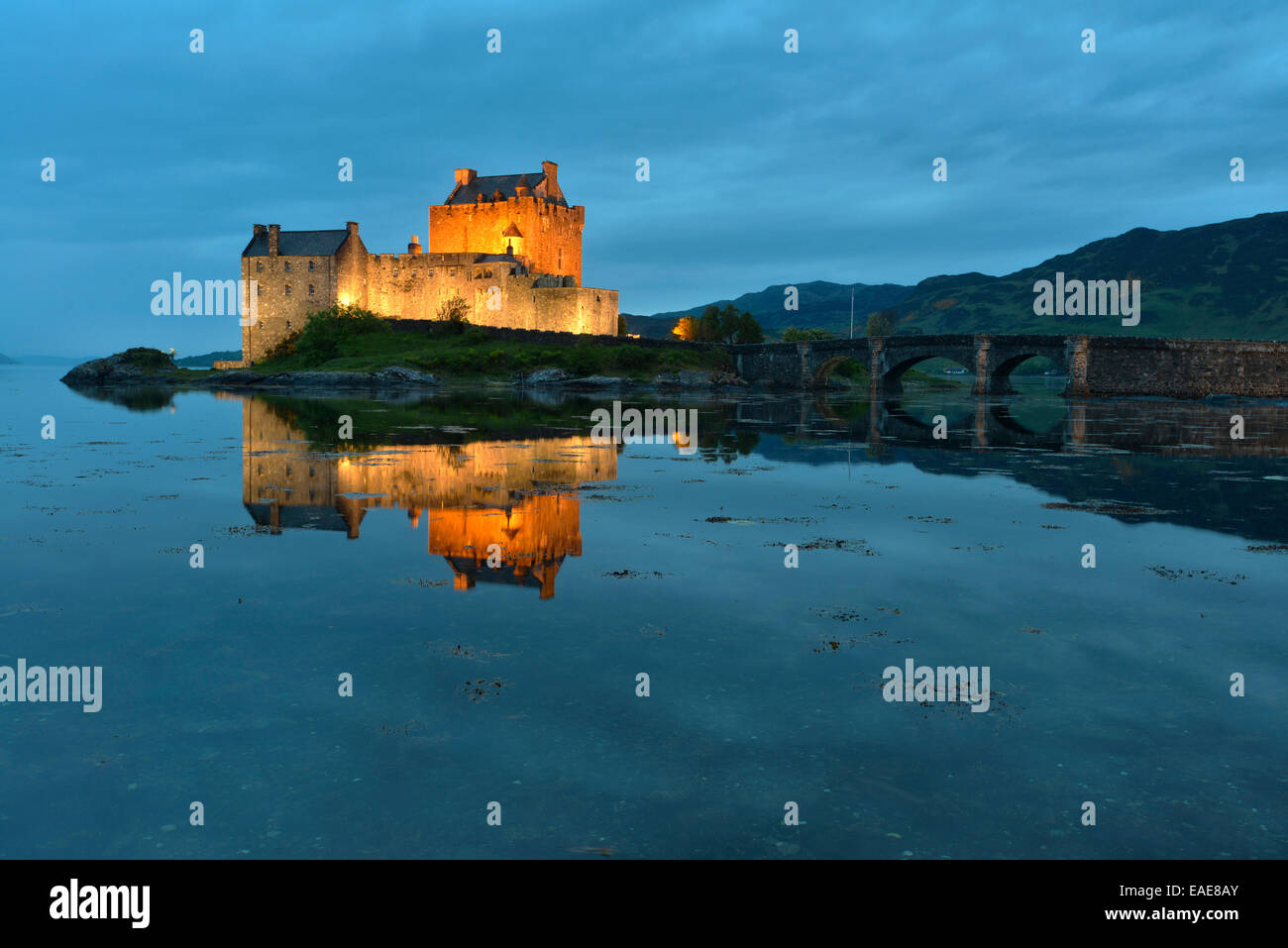 Eilean Donan Castle, sede ancestrale del clan scozzesi di Macrae, riflessa in Loch Duich in serata, Dornie, Highlands Foto Stock