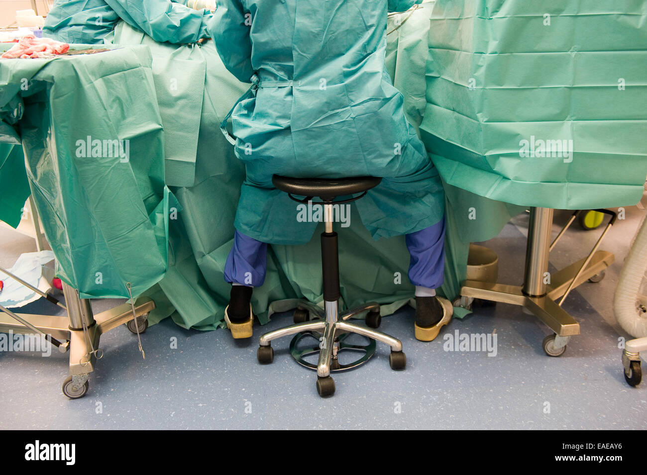 Un chirurgo in indumenti protettivi durante il funzionamento in un ospedale Foto Stock