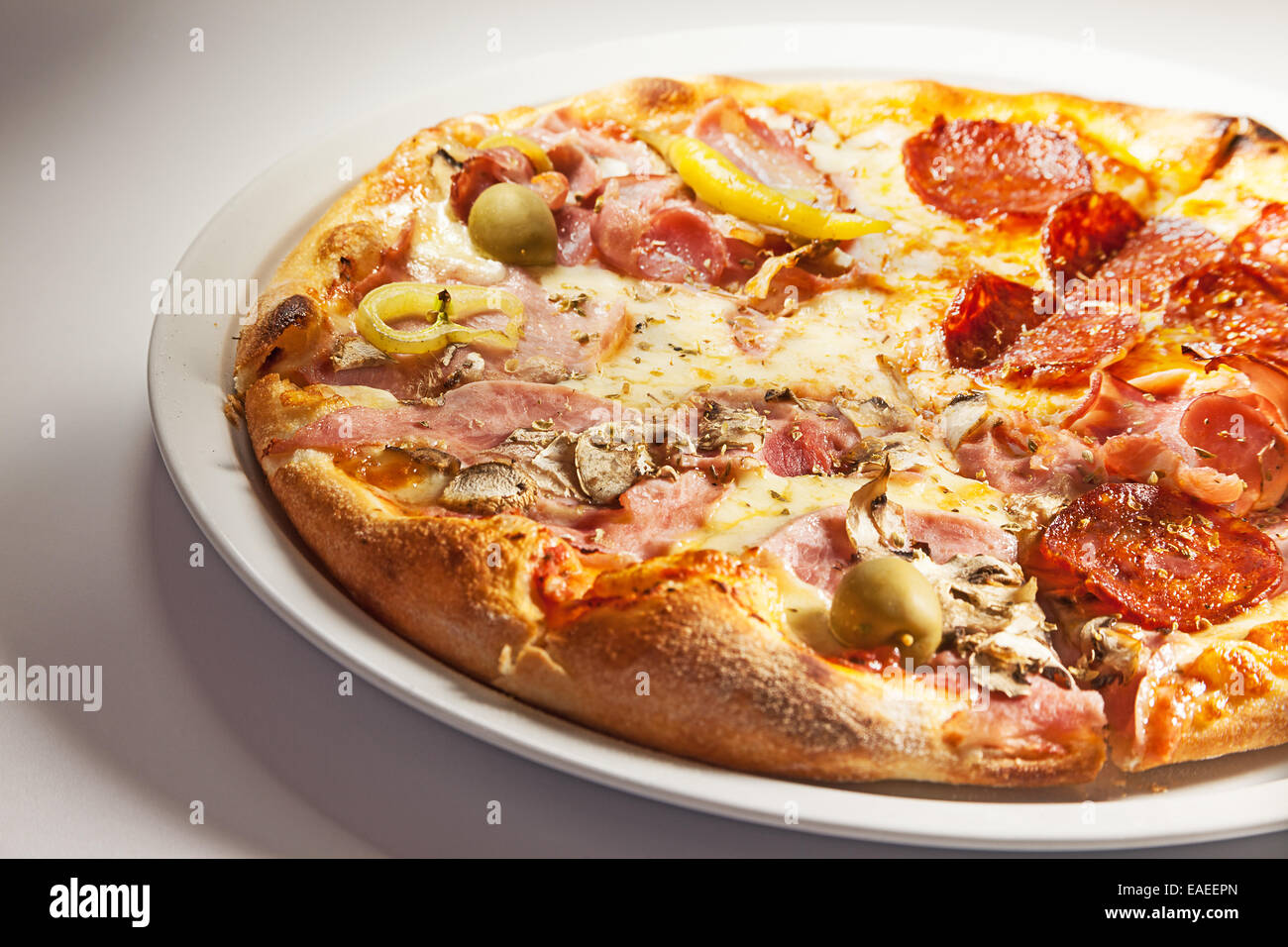 Pizza con prosciutto su un lato e salsicce sull'altro. Foto Stock