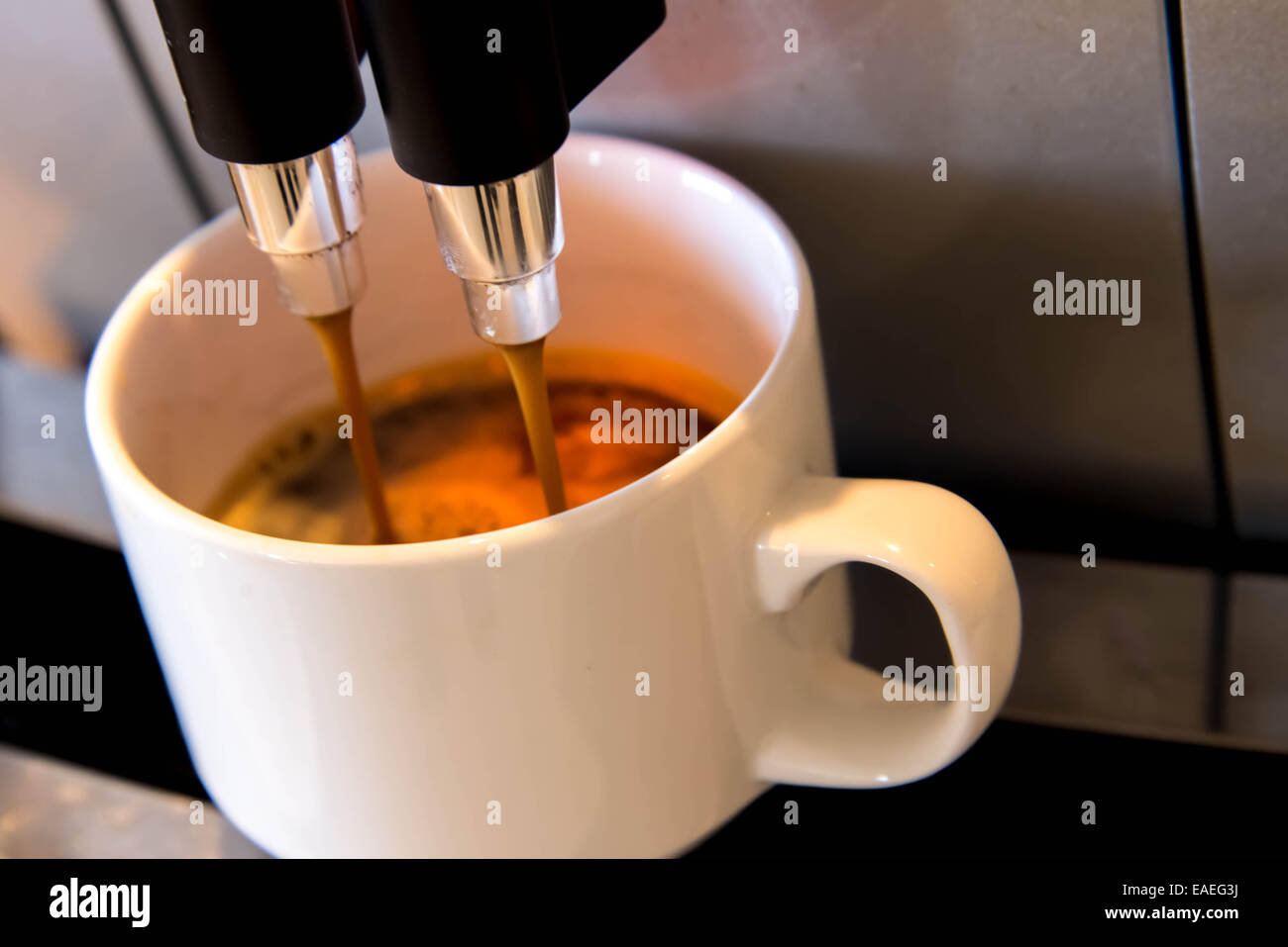 Una tazza bianca sotto la macchina del caffè Foto stock - Alamy