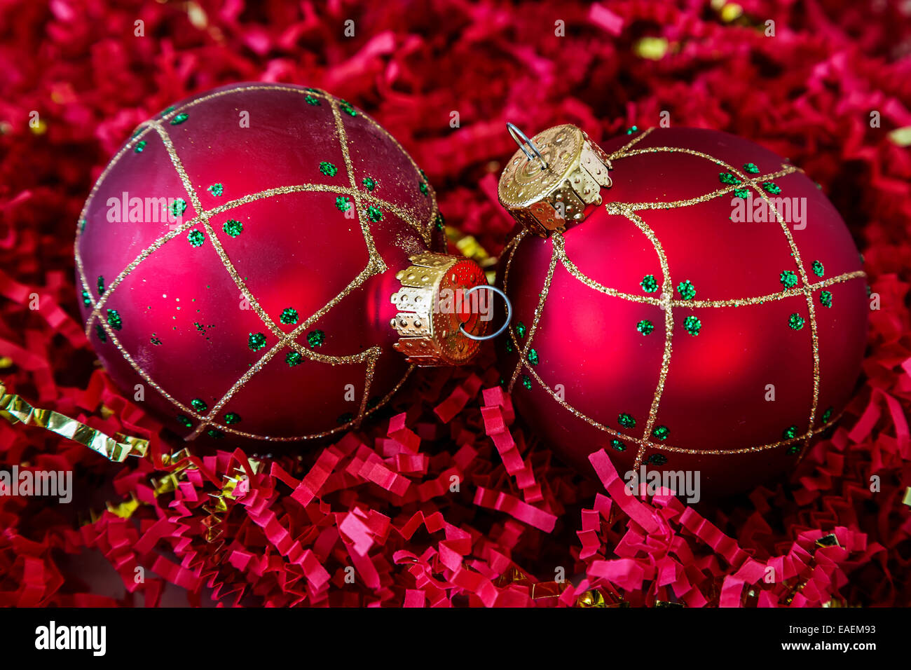 Le decorazioni di Natale giacente su un letto di crinkle tagliare la carta tagliuzzata. Foto Stock