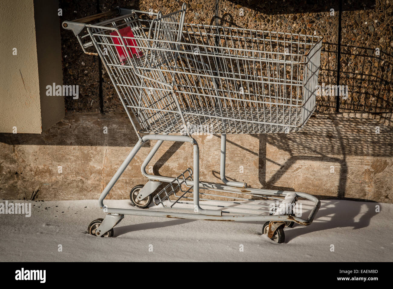 Inutilizzato un carrello seduta nella neve a lato del centro commerciale. Foto Stock
