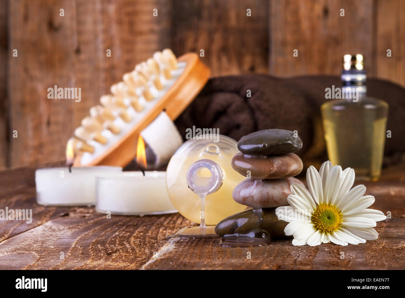 Zen pietre di basalto e olio di spa con candele su sfondo di legno Foto Stock