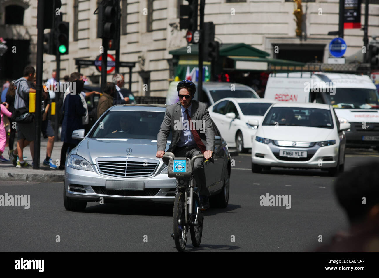 Un ciclista viaggia nella parte anteriore del traffico a Londra in Trafalgar Square Foto Stock