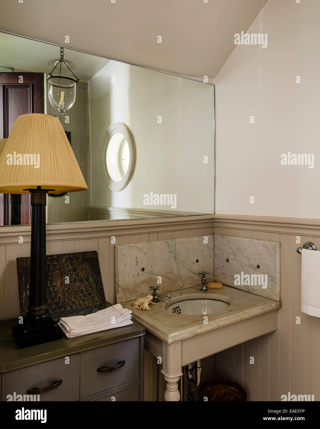 Antico bacino rubinetti e impostare in un piano in marmo con pannelli di marmo in valutazione guardaroba con specchio grande Foto Stock