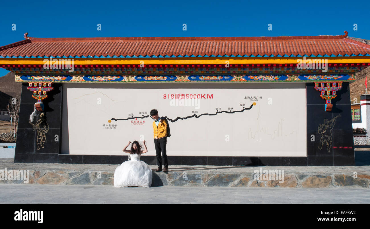 Agli sposi novelli da Guangzhou pongono al km 5000 marcatore sulla Highway 318, Tibet occidentale Foto Stock