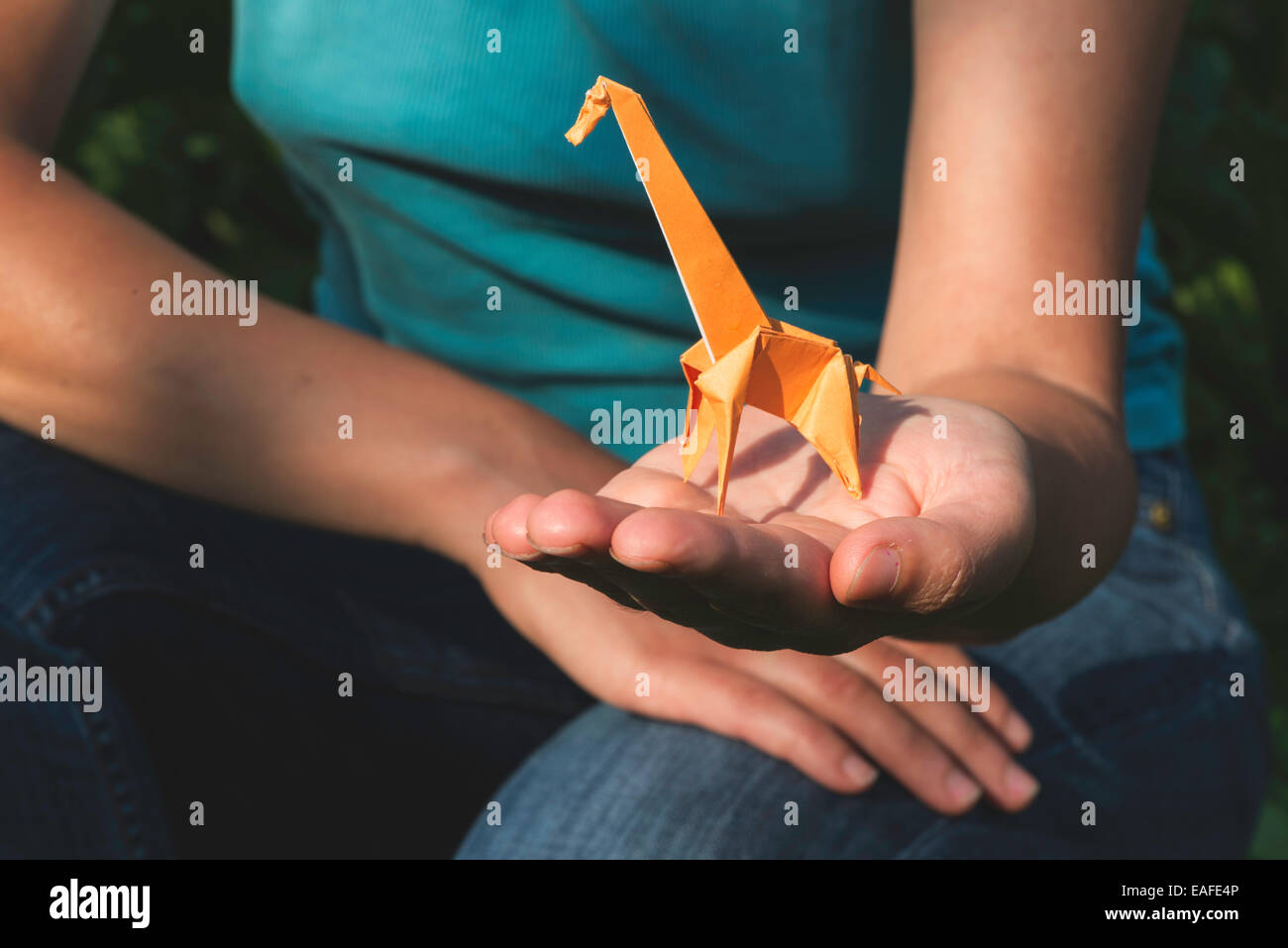 Origami di colore arancione giraffa sulla mano. Foto Stock