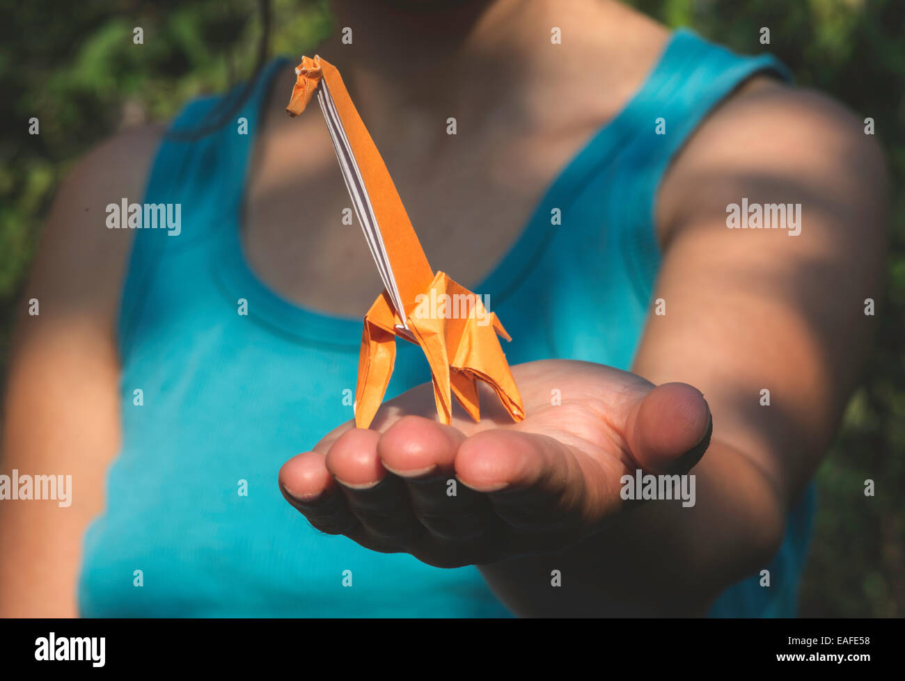 Origami di colore arancione giraffa sulla mano. Foto Stock