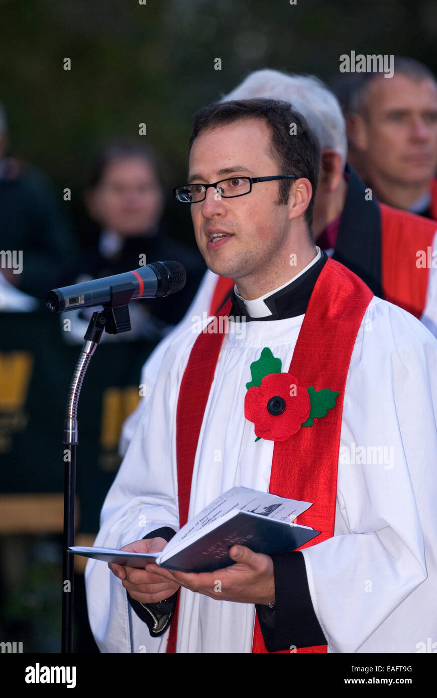 Membro del clero locale affrontando la congregazione accanto al nuovo memoriale di guerra sul ricordo domenica, quattro marchi, Alton, HAMPSHIRE, Foto Stock
