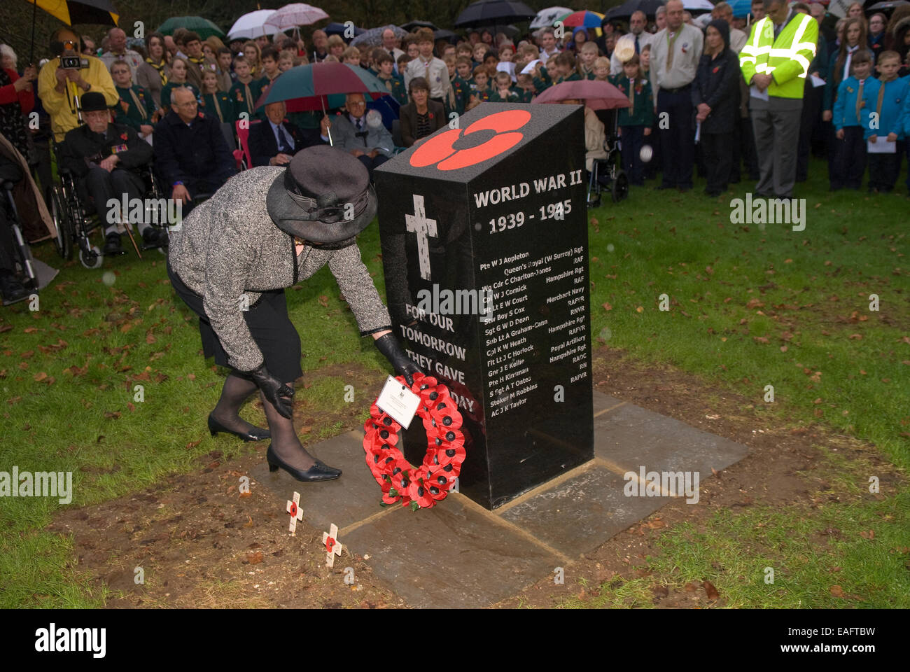 Signora anziana immissione corona di fiori accanto al nuovo memoriale di guerra sul ricordo domenica, quattro marchi, Alton, HAMPSHIRE, Regno Unito. Foto Stock