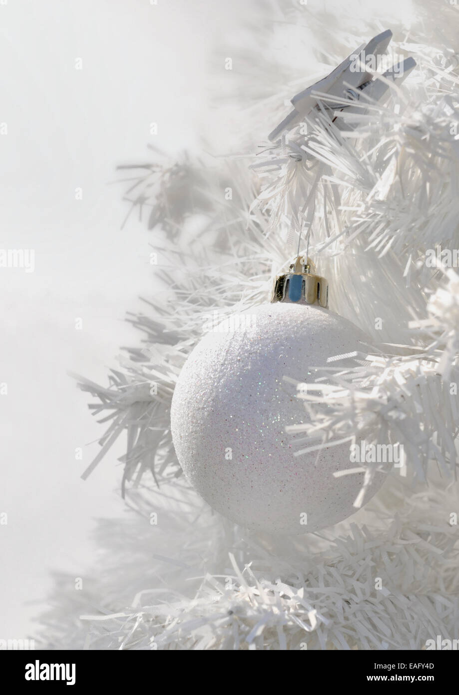 Primo piano di una palla di Natale su un ramo di bianco in bianco albero di natale Foto Stock Primo piano di una palla di Natale su un ramo di bianco in bianco albero di natale Foto Stock