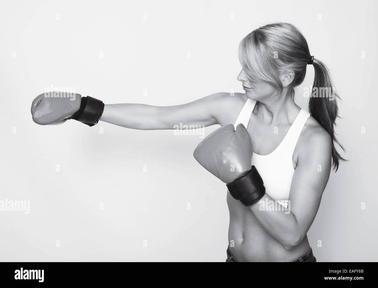 Un giovane sportivo da donna con i guantoni, in bianco e nero Foto Stock
