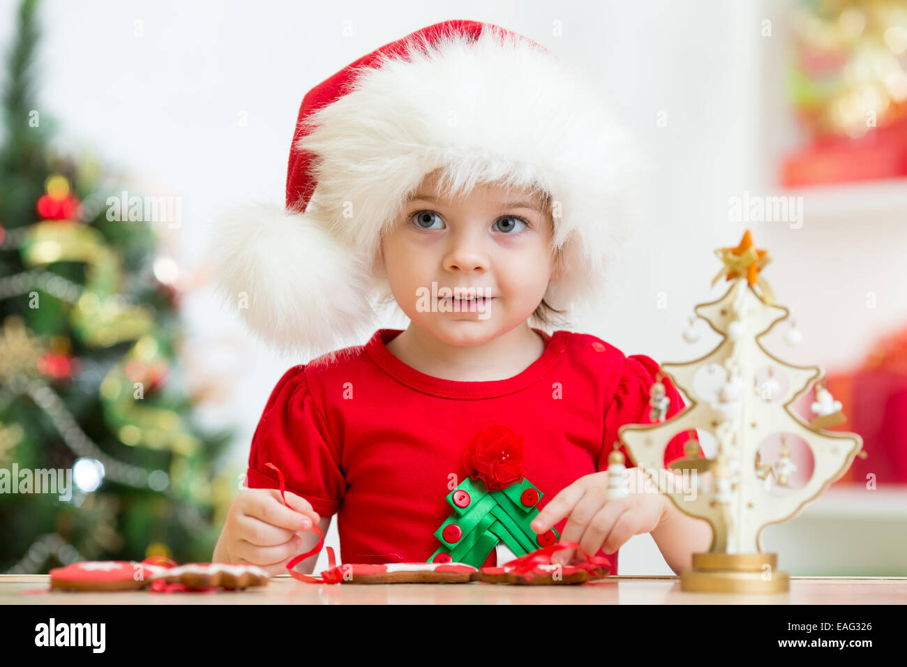 Bambino ragazza in Santa hat rendendo le decorazioni di Natale Foto Stock