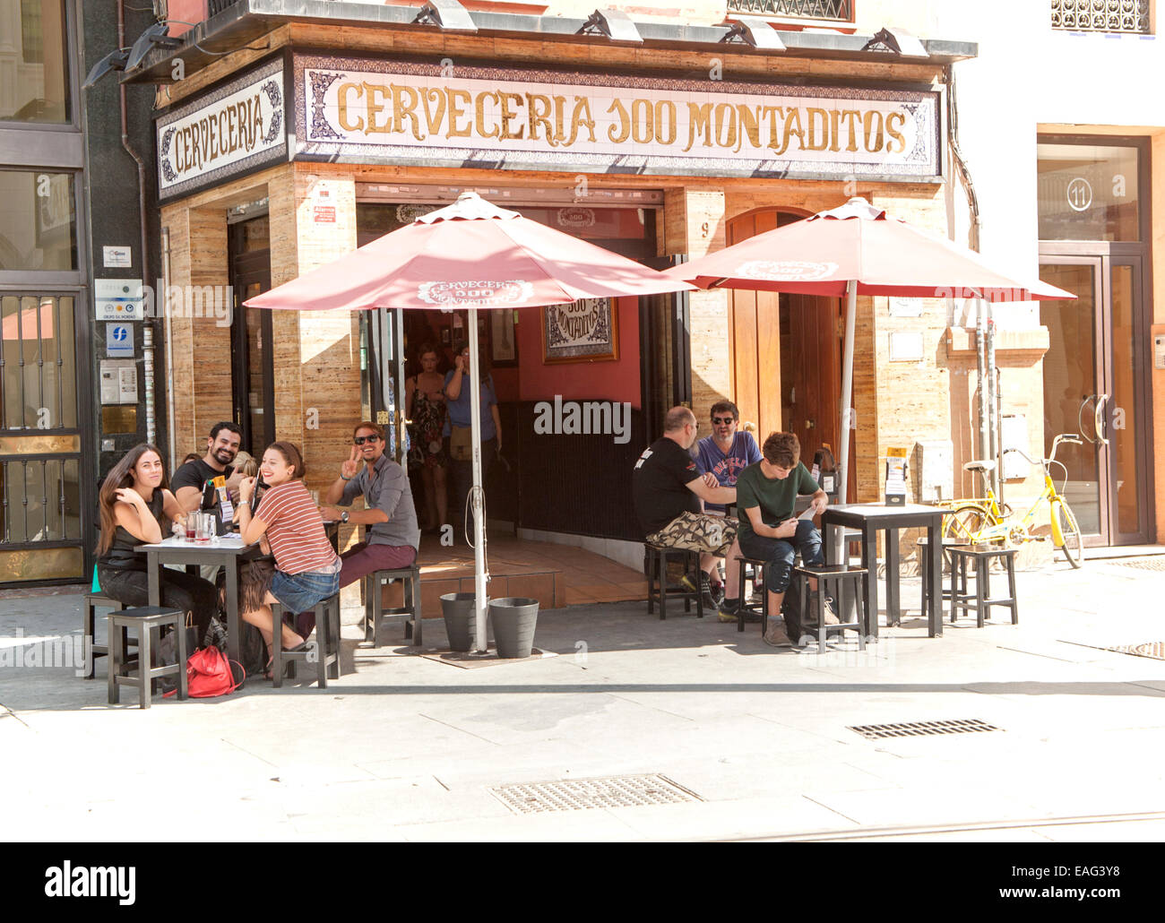 Le persone felici sventolano fuori dai tradizionali cerveceria bar nella zona centrale di Seville, Spagna Foto Stock