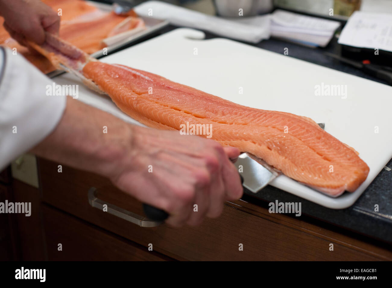 Rimuovere la pelle dal greggio di filetto di salmone Foto Stock