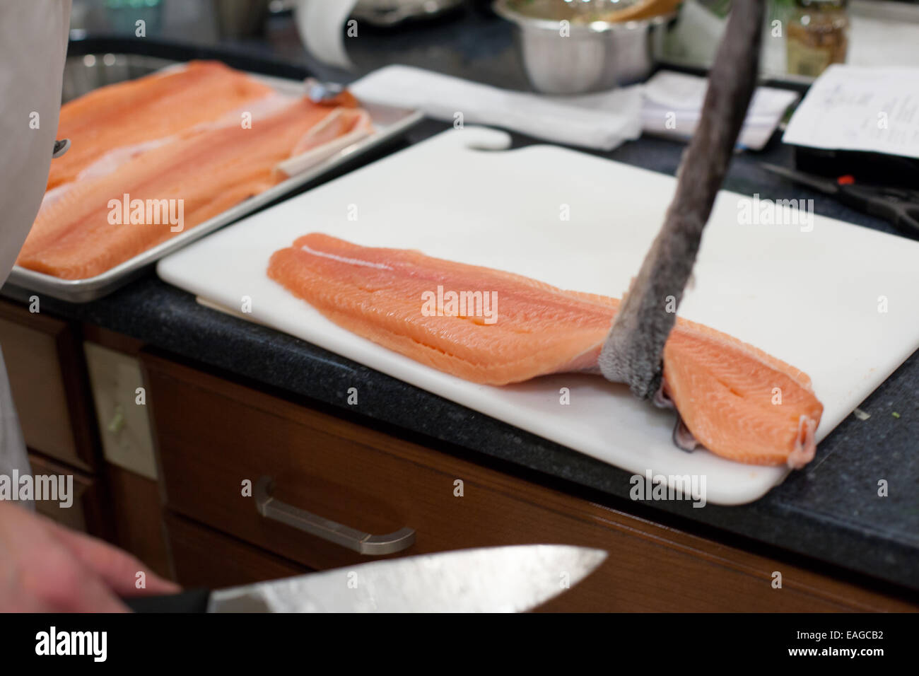 Rimozione della pelle da un grezzo di filetti di salmone Foto Stock