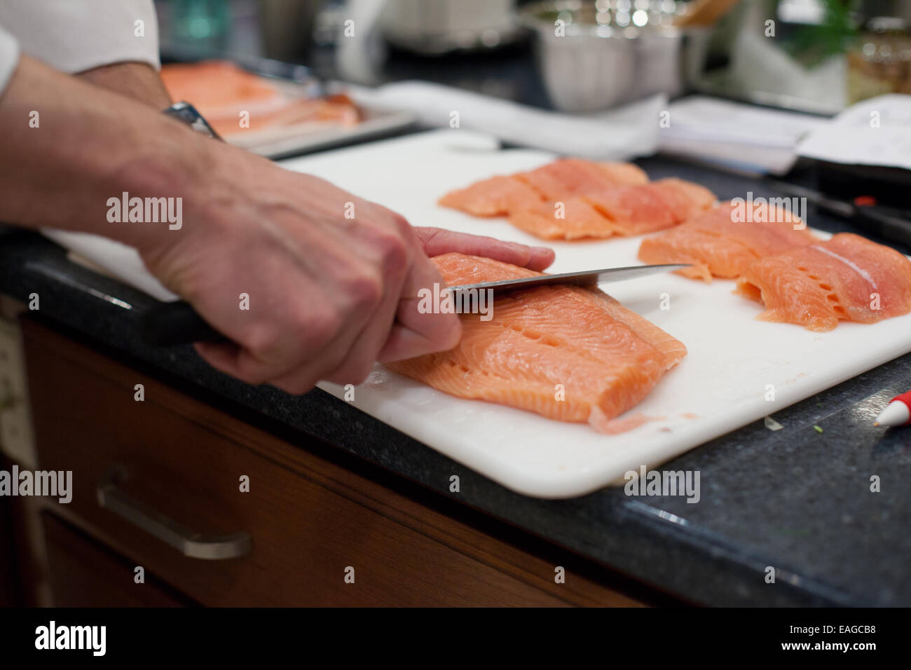 Lo Chef mani il taglio di materie di filetti di salmone Foto Stock