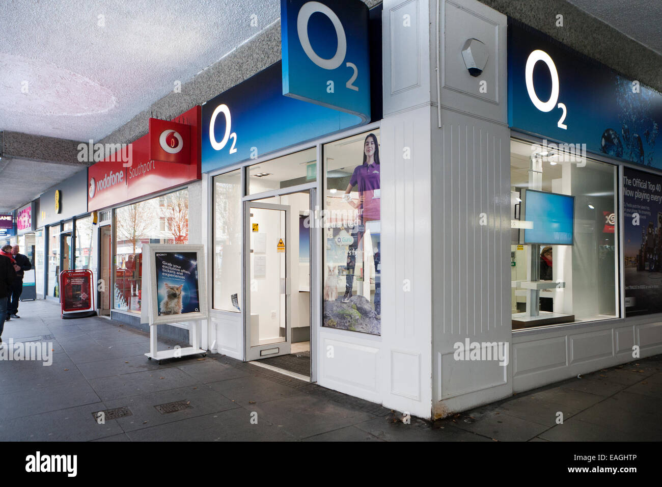 3 telefono mobile memorizza adiacente a ciascun altro EE, Vodafone, O2, Chapel Street, Southport, Merseyside, Regno Unito. Foto Stock