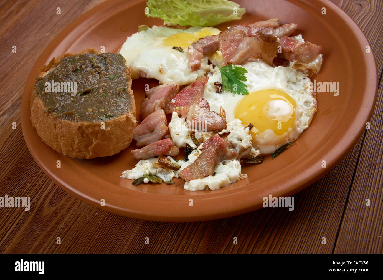 Paese europeo prima colazione - uova fritte, pancetta fritta e baguette con melanzana pasting Foto Stock
