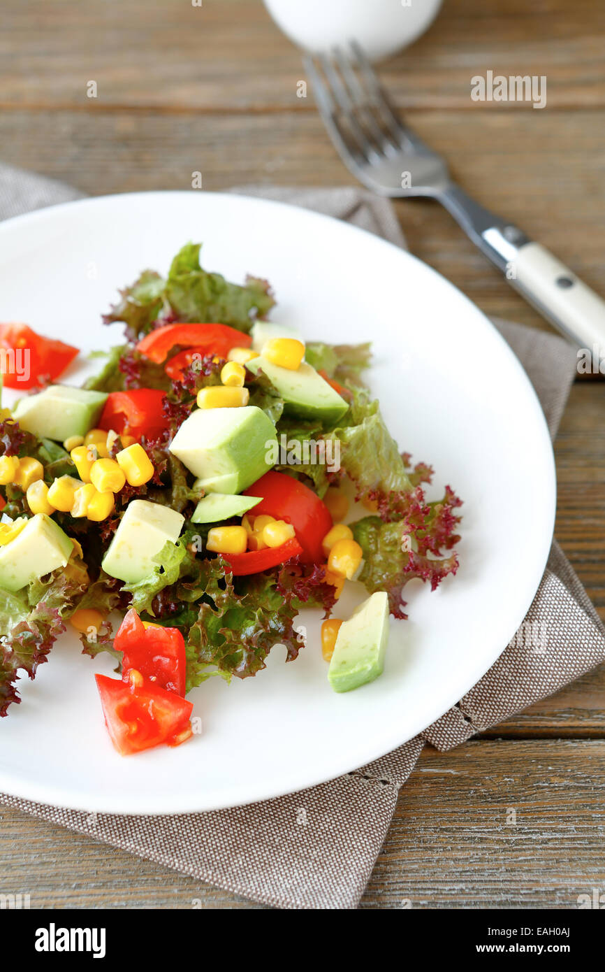 Estate con insalata di avocado, i pomodori e il mais su una piastra, cibo Foto Stock