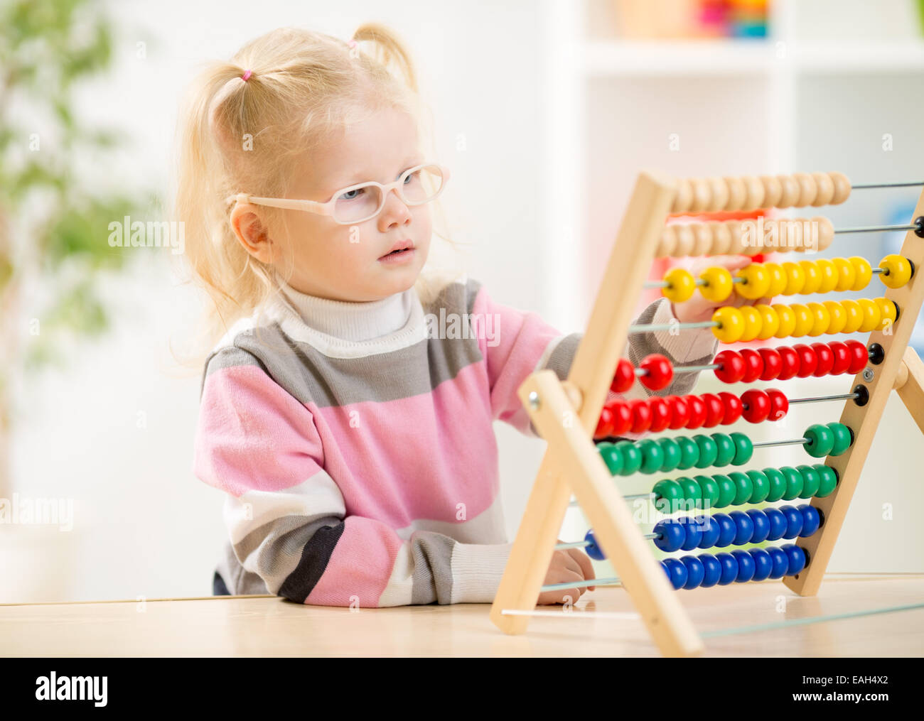 Funny kid in eyeglases conteggio utilizzando abacus Foto Stock