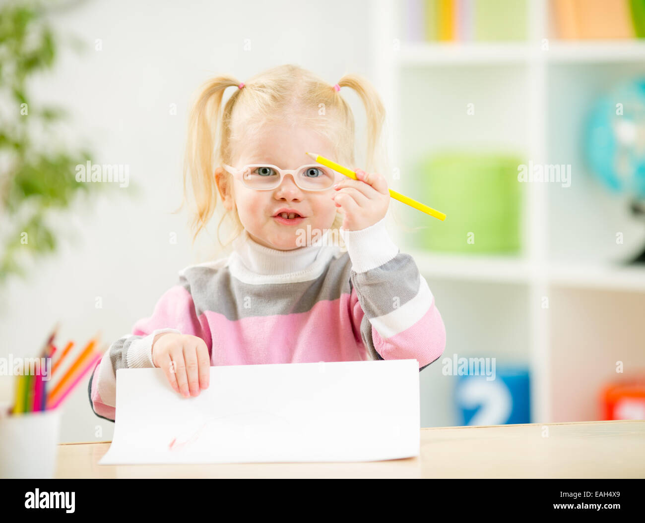 Bambino in occhiali disegno foto a casa Foto Stock