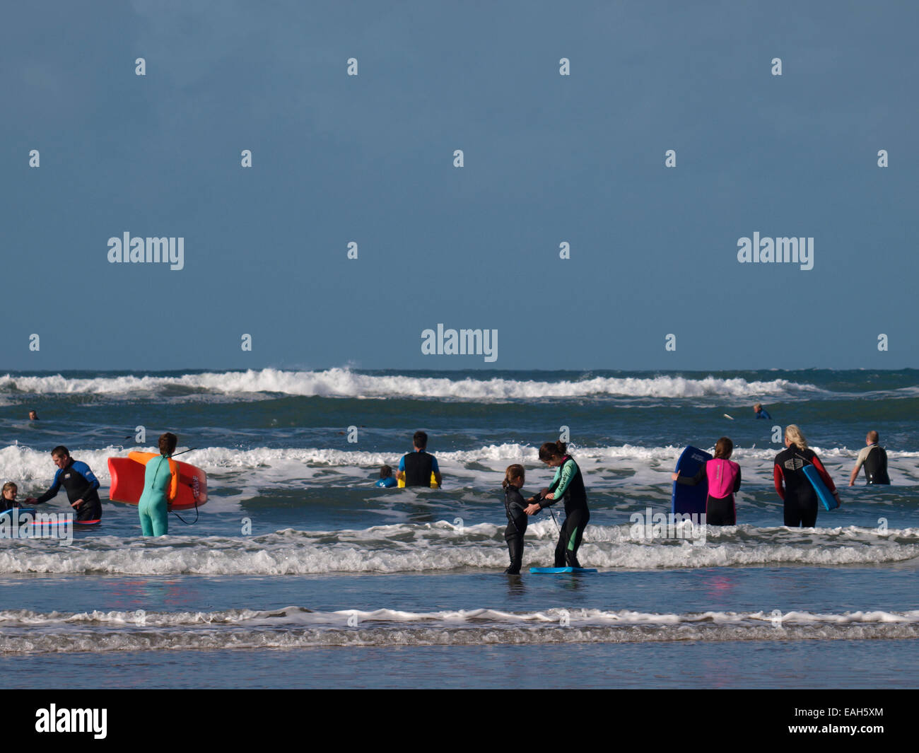 Un sacco di persone che giocano in mare durante l'autunno half term holiday, Bude, Cornwall, Regno Unito Foto Stock