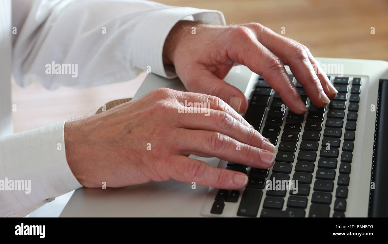 Chiudere il colpo di mano maschio digitando su una tastiera portatile. Foto Stock