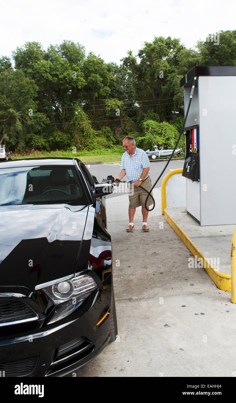 Automobilista il riempimento di auto sportiva con carburante a un americano gas station USA Foto Stock