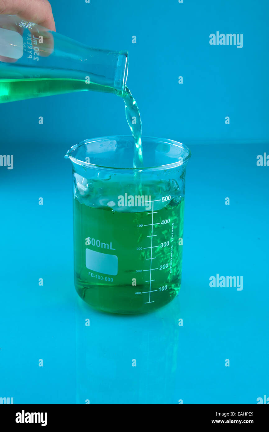 Il versamento di un liquido verde in un becher Foto Stock