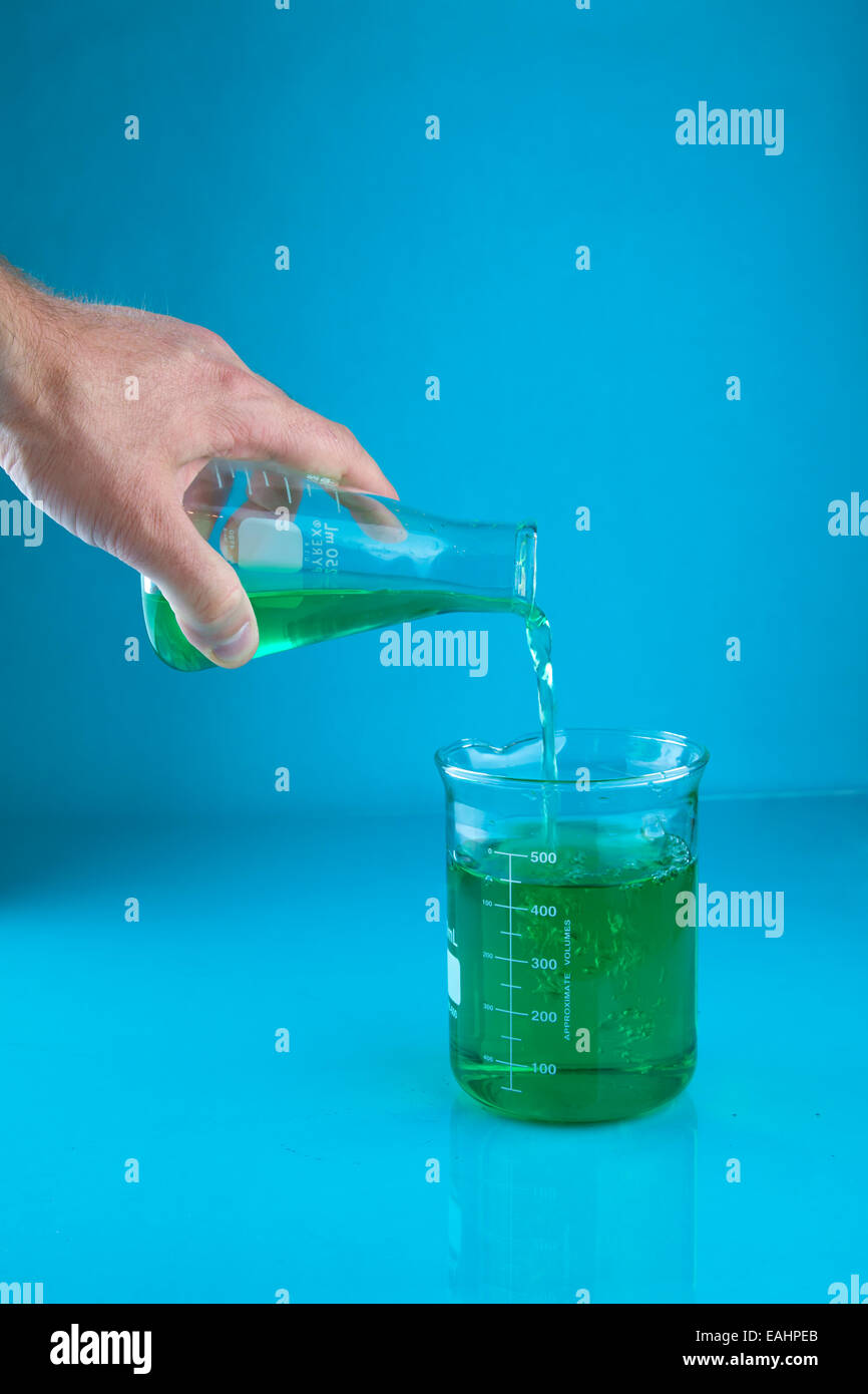 Il versamento di un liquido verde in un becher Foto Stock